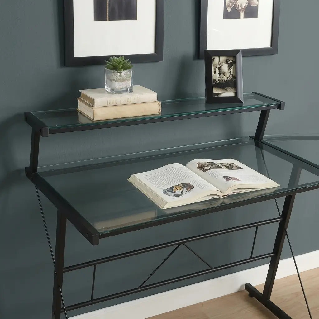 Black metal frame L-shaped gaming desk with clear glass top and shelf