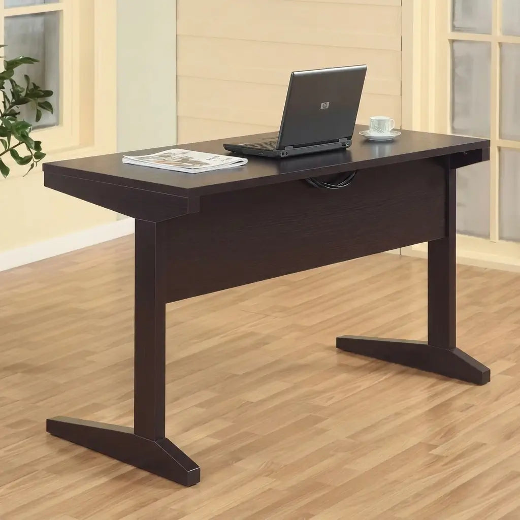 Espresso finish wood computer desk with wide desktop surface and L-shaped legs, placed in a home office or living space