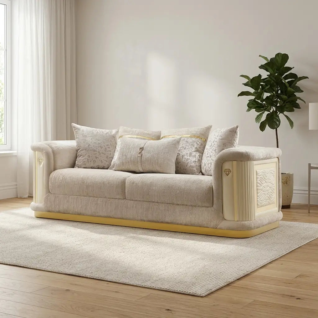 Elegant cream-colored sofa with carved details, plush patterned throw pillows, and a yellow-gold base trim on a textured cream rug