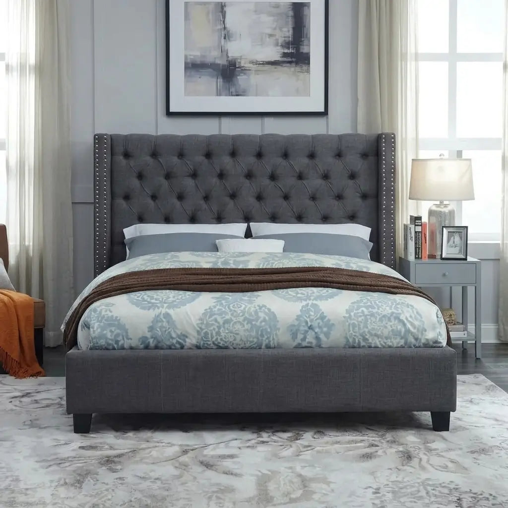 Contemporary velvet bed with tufted wingback headboard, nailhead accents, and modern chrome legs styled with bedding in a bedroom