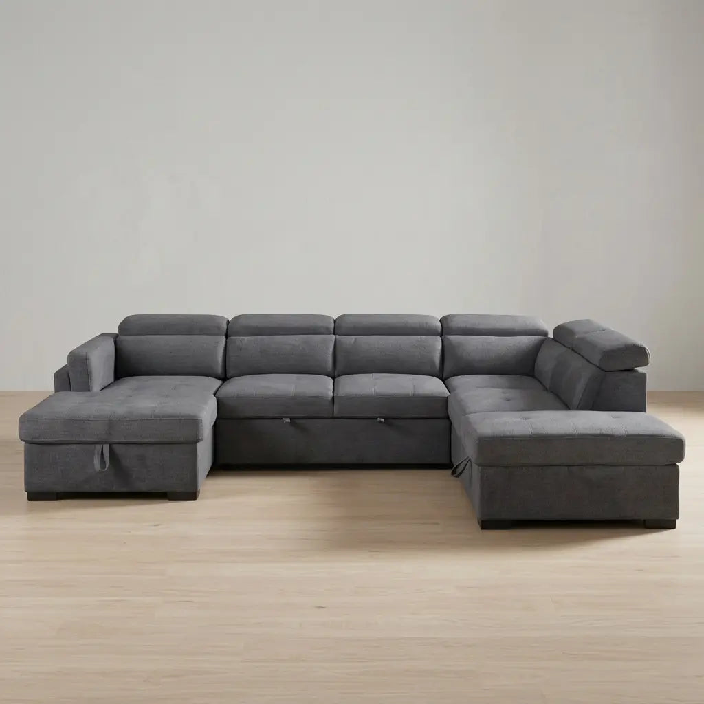 Modern grey fabric sofa bed featuring a left-hand facing chaise, adjustable headrests, and floating storage ottoman in a living room