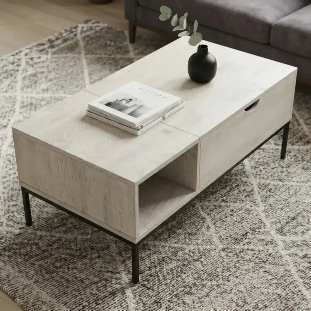 Washed oak coffee table with lift-top surface, open sled-style black metal base, and side shelf holding books and décor