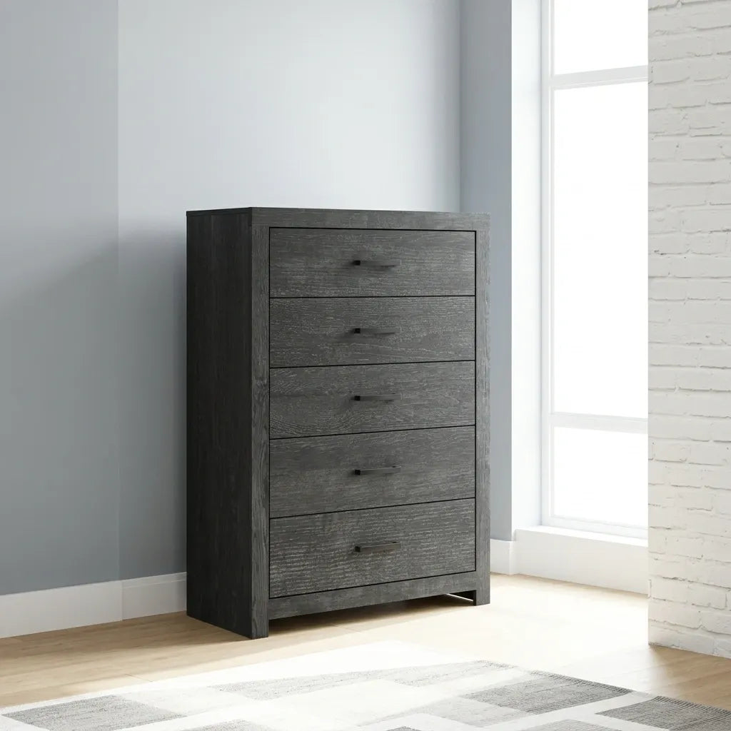Dark charcoal gray wood chest with black metal handles next to matching bedroom furniture